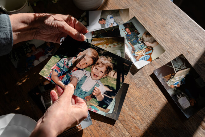 private Kinderfotos werden in einer Hand gehalten