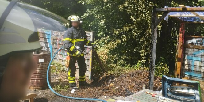 Feuerwehrleute bei Löscharbeiten im Garten des Jugendhauses.