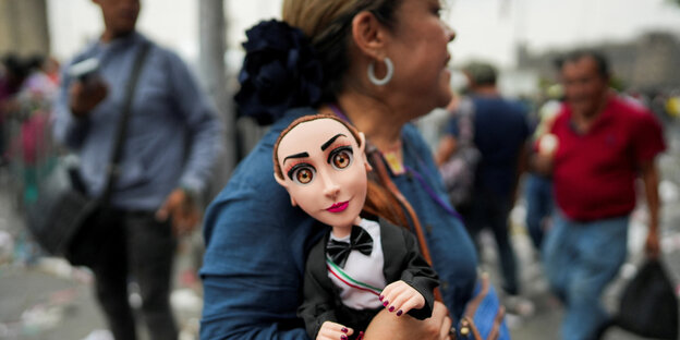 Eine Person hält eine Puppe, die die Präsidentschaftskandidatin der regierenden MORENA-Partei Claudia Sheinbaum darstellt, am Tag ihrer Abschlusskundgebung auf dem Zocalo-Platz in Mexiko-Stadt, Mexiko, 29. Mai 2024. REUTERS/Alexandre Meneghini