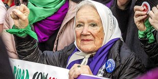 Alte Damen mit weißem Kopftuch und gereckter Faust