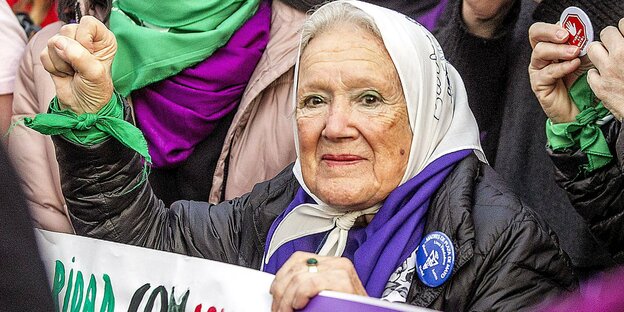 Alte Damen mit weißem Kopftuch und erhobener Faust