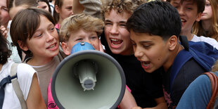 4 Jungs rufen in ein Megaphone