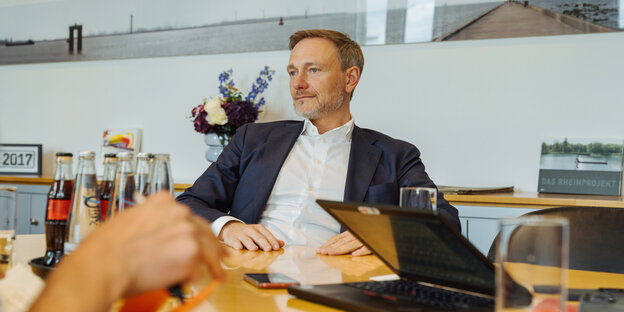 Christian Lindner sitzt an einem Besprechungstisch in seinem Büro