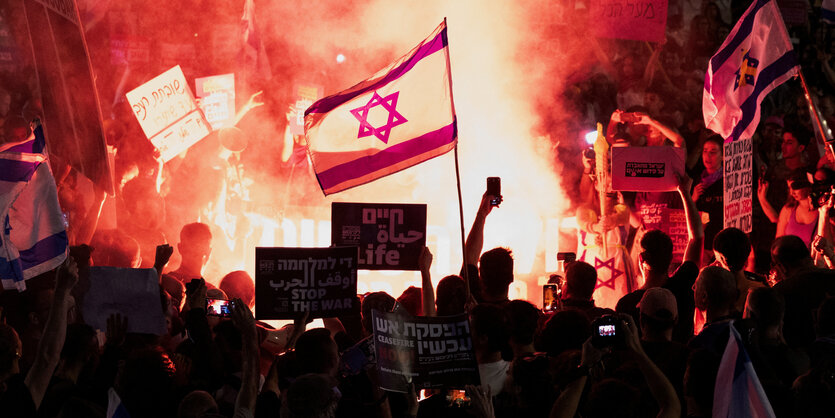 Eine Israelflagge in einer Demonstrationsmenge.