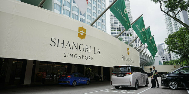 Gebäude mit der Aufschrift Shangri-La mit Flaggen und Auto