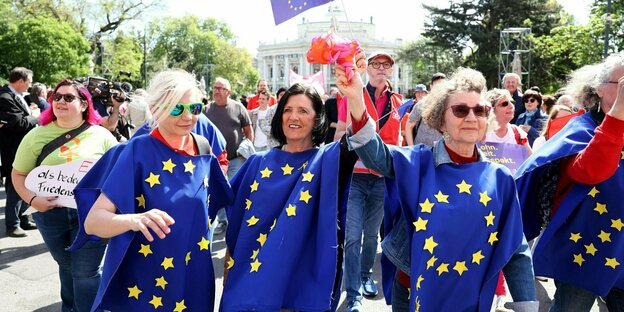 Mehrere Frauen tragen die Europaflagge und laufen bei einer Demo in Wien mit