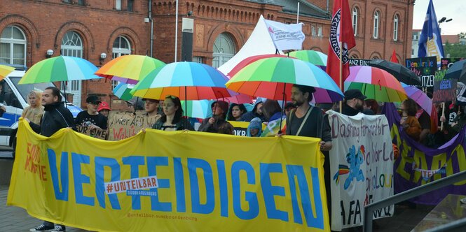 Demonstration mit Transparent und Fahnen.