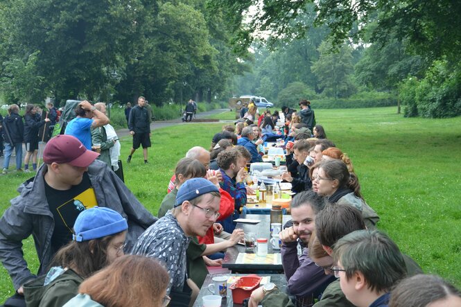 Menschen an einer langen Kaffeetafel.