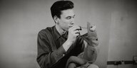 Jim Henson schaut einer Kermit-Puppe in den Mund (Schwarzweiß-Fotografie)