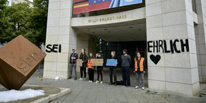 Menschen stehen vor dem Willy-Brandt-Haus. An den Säulen steht: "Sei ehrlich"