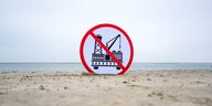 Ein Schild gegen die geplante Erdgasförderung steckt im Sand eines Strandes auf Borkum.
