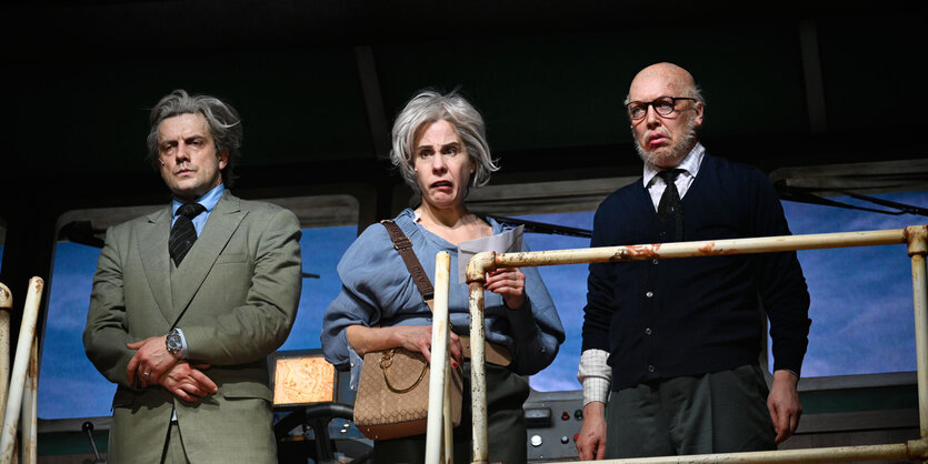 Christoph Jöde, Ute Hannig und Lina Beckmann stehen hinter einem Geländer und blicken pikiert.