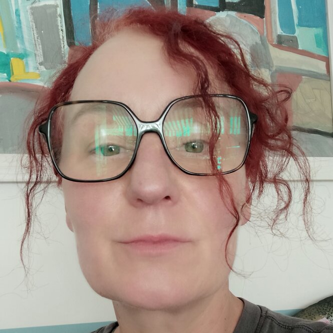 Frau mit großer Brille und rötlichen Locken