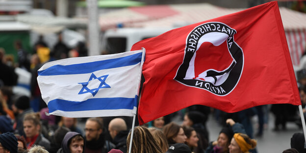 Bei eienr Dmeonstration wehen eine Antifa- und eine Israel-Flagge