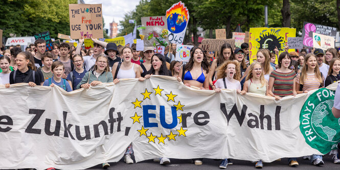 Jugendliche bei einer Demonstration mit Transparent.