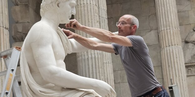 Ein Restaurator arbeitet an einer Skulptur im Pergamon-Museum in Berlin.