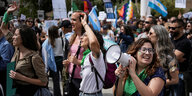 Demonstration von Frauen, eine Frau hält ein Megafon in der Hand und lacht