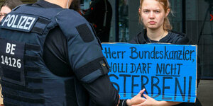 Eine Frau hält ein Schild in der Hand, auf dem steht: Herr Bundeskanzler, Wolli darf nicht sterben.