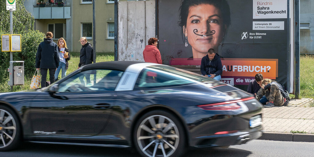 Ein bemaltes Wahlplakat an einer Bushaltestelle.