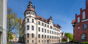 Ein historisches Gebäude in weiß mit einem kleinen Turm an einer Ecke