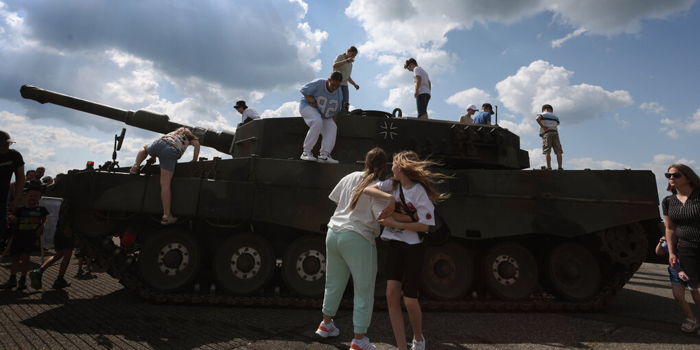 Besucher des Tages der Bundeswehr klettern auf einem Leopard 2 Panzer herum.