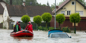 Ein Rettungsboot in einer überfluteten Straße.