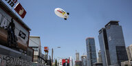 Ein Zeppelin fliegt über Tel Aviv. Darauf die Aufschrift "Save Them Now!".