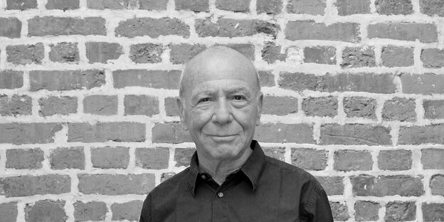 Eric Hazan als älterer Mann vor einer Backsteinmauer auf einer Schwarz-Weiß-Aufnahme