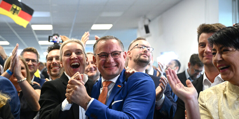 Alice Weidel und Tino Chrupalla jubeln gemeinsam, umringt von Anhängern