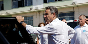 Griechenlands Premierminister Kyriakos Mitsotakis steigt vor einem Athener Wahllokal in ein Auto.