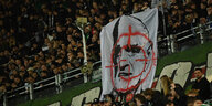 Fans zeigen im Stadion ein Konterfei von 96-Geschäftsführer Martin Kind mit einem Fadenkreuz.