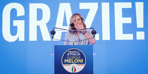 Italiens Premierministerin Giorgia Meloni ist überrascht vom Erfolg und tritt mit der Schrift GRAZIE vor die Presse