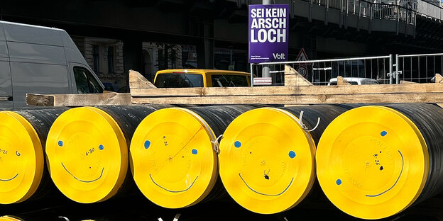 Gelbe Tonnen mit Smileys und Volt-Wahlplakat