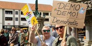 Menschen laufen mit Schildern auf einer Demonstration, Aufschrift: „Demo? Demo! Demokratie“ und „Wir treten ein für ein weltoffenes Thüringen“