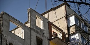 Ein Bauarbeiter installiert Fertigbauteile an einem Wohnhaus