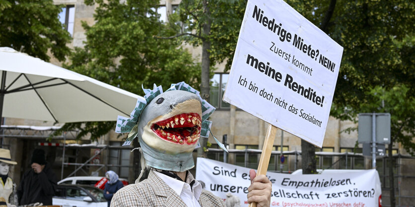 Demonstrant mit Plakat "Niedrige Miete? Nein! Zuerst kommt meine Rendite!"