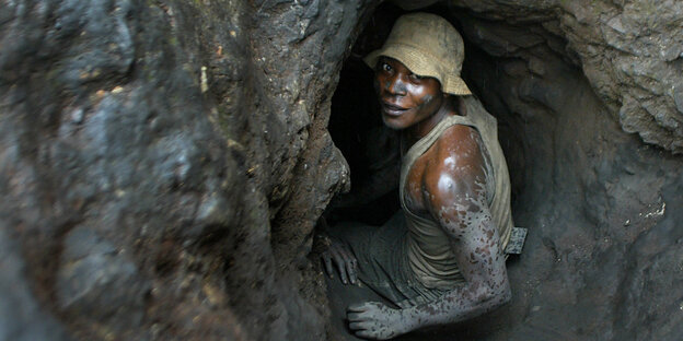 Ein Mann schaut zurück aus dem Eingang eines Tunnels einer Kobaltmine