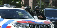 Bewaffnete Polizisten patrouillieren vor dem Amsterdamer Gerichtsgebäude, wo die Urteile im Prozess gegen neun Männer verkündet werden, die verdächtigt werden, an der Ermordung des beliebten Journalisten Peter R. de Vries vor drei Jahren auf einer belebte