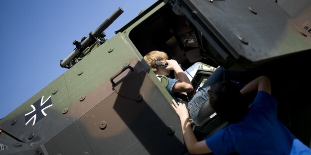 Jugendliche auf Panzerfahrzeug