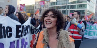 Simin geht neben anderen Demonstrant*innen bei einer Demonstration gegen Rassismus.