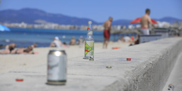 Leere Bierflaschen und -büchsen an der Strandpromenade