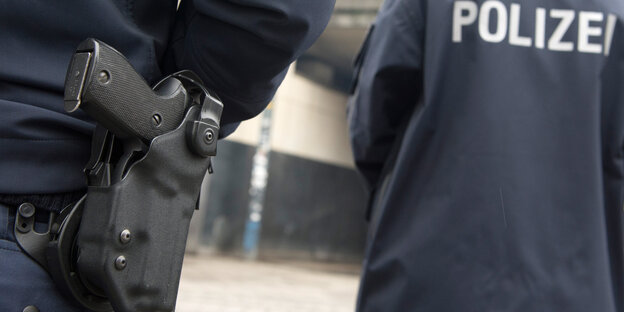 Blick auf zwei Polizisten einer Berliner Polizeistreife, die Waffe prominent im Mittelpunkt
