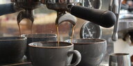 Espresso läuft in zwei Kaffeetassen.