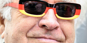 Mann mit Sonnenbrille in Deutschlandfarben