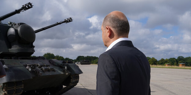 Olaf Scholz schaut auf einen Panzer
