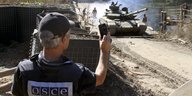 Ein OSZE-Beobachter und ein ukrainischer Panzer