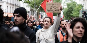Eine Frau hält eine Schild in die Höhe. darauf sind die Worte " Vive le Front Populaire" zu lesen