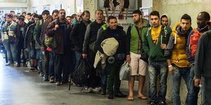 Flüchtlinge warten in einer Bahnhofshalle.