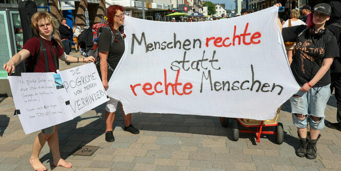 Demo gegen Rechte auf Sylt - Menschenrechte statt rechte Menschen steht auf dem Schild mehrerer junger LEute