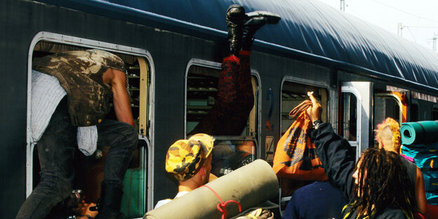 Punks beim Einsteigen durchs Fenster in einen Zug, aufgenommen auf Sylt, 01.08.1995.